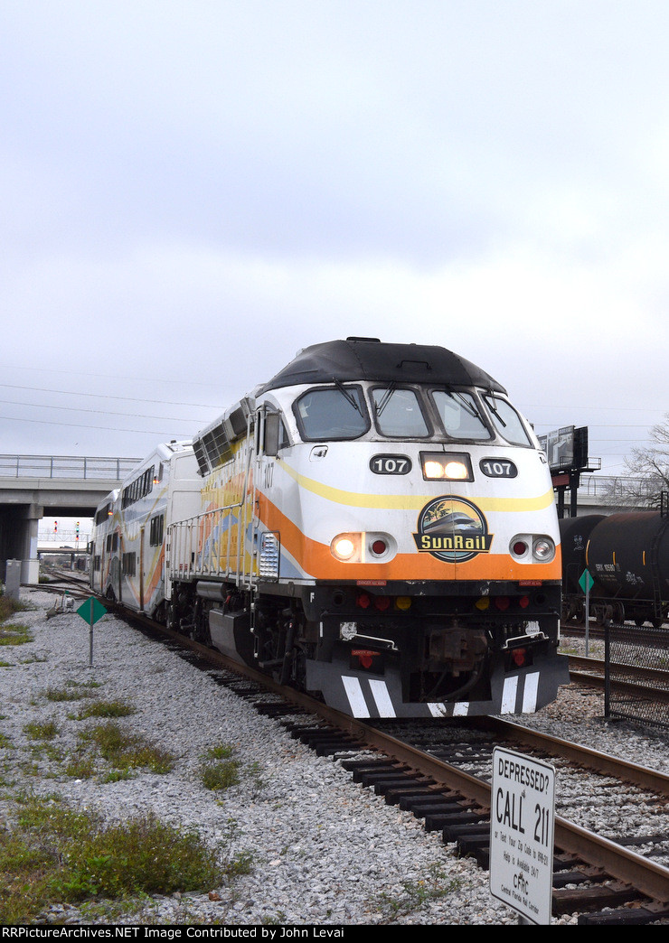 MP36PH-Q #107 powers a DeLand bound Sunrail Train into Sand Lake Road depot during the height of the morning rush hour.